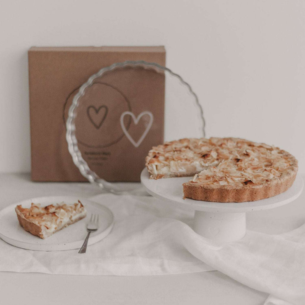 Große Tarteform aus Borosilikatglas mit wellenförmigem Rand und weißem Herz in der Mitte, backofen- und spülmaschinenfest