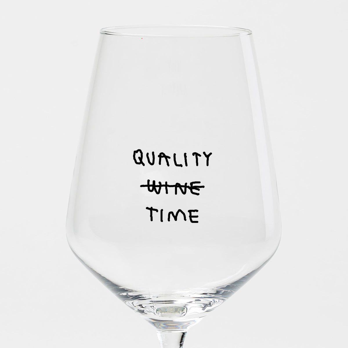 Liquid Dinner Weinglas aus klarem Glas mit schwarzem „Quality Wine Time“-Schriftzug, bei dem „Wine“ durchgestrichen ist.